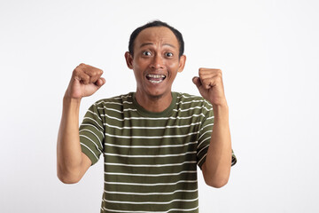 Fototapeta premium A man wearing a green shirt with white stripes is raising his hands up in the air in a gesture of celebration or victory.