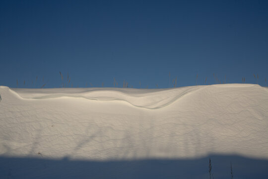 Winter Snowdrift Against Clear Blue Sky on a Sunny Day