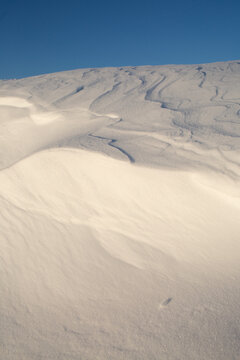 Soft White Snow Drifts Against Bright Blue Sky