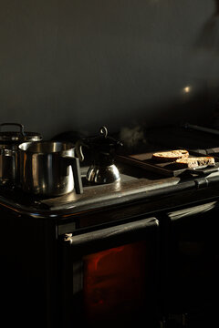 Vintage Kitchen Stove with Steaming Pots and Warm Glow