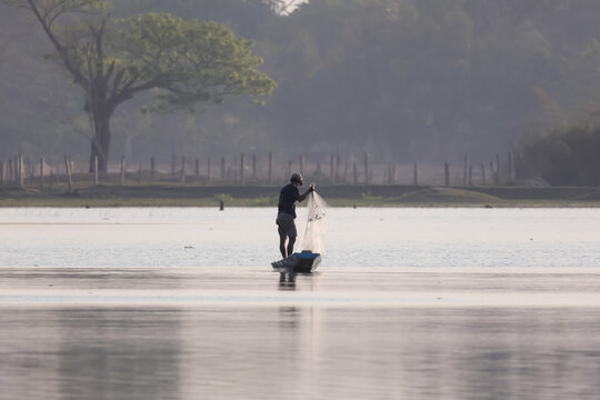 a fisher man fising in the lake in the evening