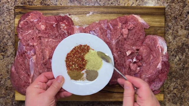Preparing the turkey thigh for the roulade. Stir the spices with a teaspoon into the prepared meat.
