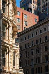 Obraz premium New York City, Flatiron District, Manhattan, along Broadway. Architectural detail featuring ornate building façades and rooftop water towers in strong sunlight