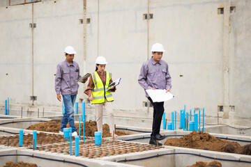 Reinforced concrete structures. Man and woman construction worker working together at workplace. Group of professional construction engineering people in hardhat safety helmet. Unity and teamwork