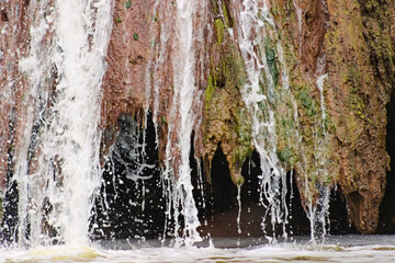 Seawater cascades over eroded rock formations at Rat Beach, California, revealing coastal textures shaped by tide, salt, and time. © Savion
