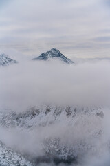 Sharp mountain summits rise above a smooth cloud layer, creating a surreal, floating effect. The scene balances strength and calm, Krivan, Tatra Mountains