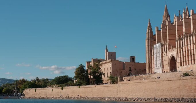 Panning view of Palma Cathedral and Almudaina Palace along the Majorca coast. Sunny day in Spain. Pan shot.