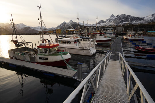 Husoy harbor with fishing trawlers and winter mountains.