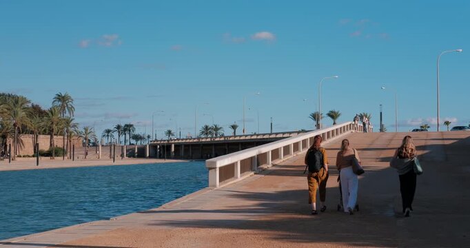 Three female walk along the waterfront promenade in Palma de Mallorca, Spain.