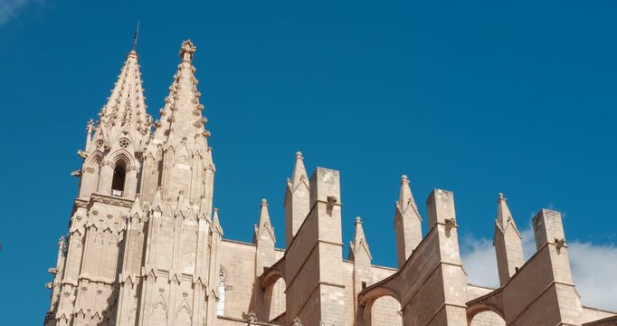 Detailed view of Palma Cathedral exterior in Palma Majorca Spain. Stunning Gothic architecture and spires under a bright blue sky.