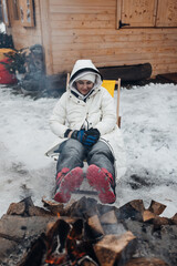 Woman Warming by Campfire at Ski Resort