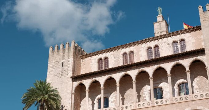 Historic architecture of Almudaina Palace and La Seu Cathedral spires under a clear blue sky in Palma de Mallorca, Spain.