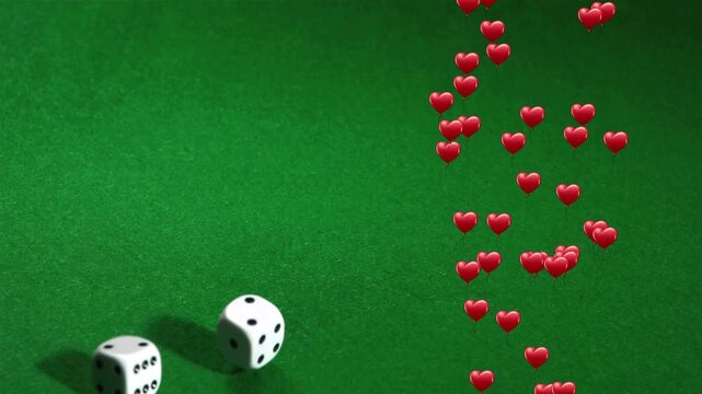 Initial nudge sending two white dice rolling on green felt as red hearts descending for luck