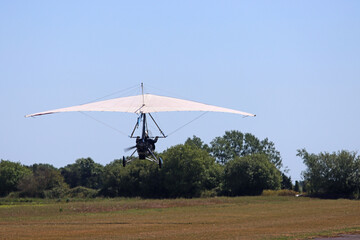Ultralight airplane taking off from a grass runway	