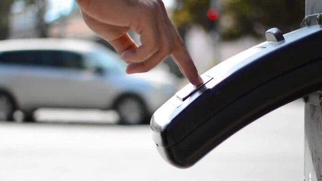 hand pressing parking meter button