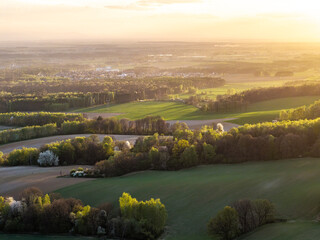 Malowniczy widok na Górę św. Anny w województwie opolskim. Wiosenny krajobraz z zielonymi polami, kwitnącymi drzewami i bazyliką na wzgórzu o zachodzie słońca. Perła Opolszczyzny. © Henryk Niestrój