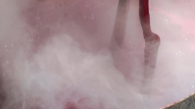 Cotton is dyed with lac dye to obtain natural colors using a traditional method in a hot pot.