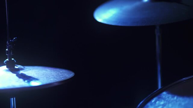 Drumer playing in blue light and slow motion