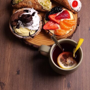 Tagliere con pasta alla frutta, cannoli e pasta con crema, tazza di t&egrave; con limone, video quadrato