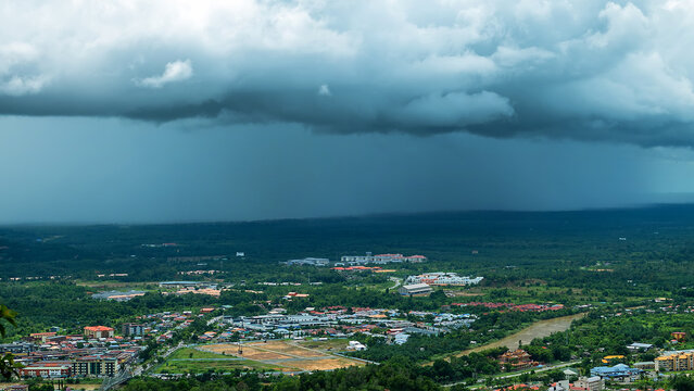 Monsoon season in the tropics. Thunderstorm, a tropical downpour over the equatorial rain forest of Borneo Island. Malaysia, city