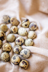 Quail eggs on a soft cloth arranged in a casual pattern during daylight hours
