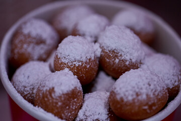 Donuts or doughnuts are made from a mixture of flour, sugar, egg yolks, yeast, and butter. Ball shaped, powdered sugar on a stacked donut