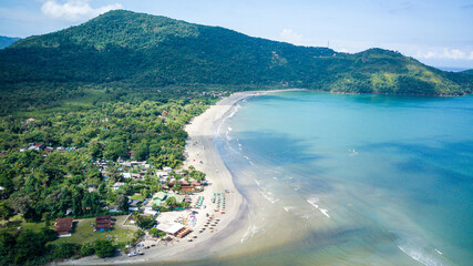 Aerial drone view of Estaleiro Beach showing clear blue tropical water, preserved native vegetation...