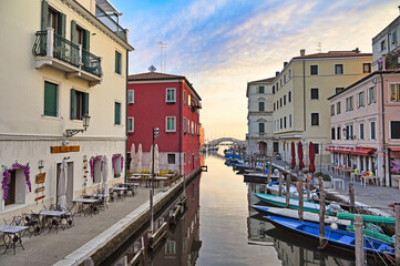 Stone bridge Ponte di Vigo across Vena water canal with boats and old buildings in historical centre of Chioggia town, Veneto Region, Italy
