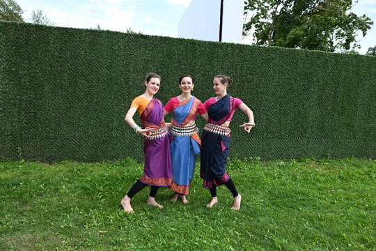 Three dancers in national costumes dance in the park on a summer day. Indian dance lessons, choreography.