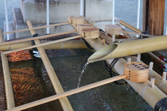 Traditional Japanese Temizuya Purification Fountain with Bamboo Ladles at Shinto Shrine