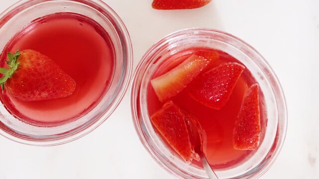 Strawberry gelatin dessert in glass bowls, close-up on a white table. High quality 4k footage