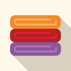 Fototapeta premium Stack of clean folded towels in orange, red, and purple with a long shadow
