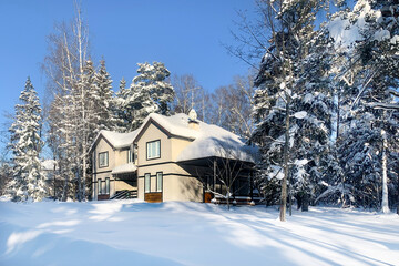 House in winter snowy white forest.