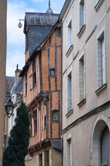 Fototapeta premium Historic Half-Timbered House France - Close-up of a beautifully preserved historic half-timbered house with a stone base and slate roof in a charming French medieval town.
