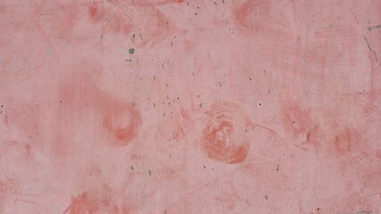 Fototapeta premium A red-colored old concrete or plastered wall surface featuring scratches, splatters, and minor stains, indicating wear and age. It serves as a grunge or vintage background texture.