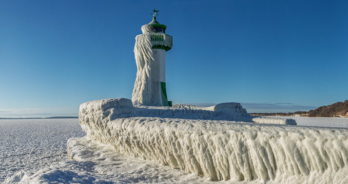 Vereister Leuchtturm Sassnitz auf R&uuml;gen, Mecklenburg-Vorpommern &ndash; Panorama der eisbedeckten Mole mit dicken Eiszapfen, Packeis und zugefrorener Ostsee, klare Wintersonne