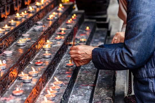 Lighting incense sticks at a temple in Chongqing, China