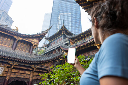 Woman using mobile phone in traditional temple setting