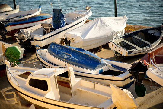 Boats docked at marina under a sunlit sky