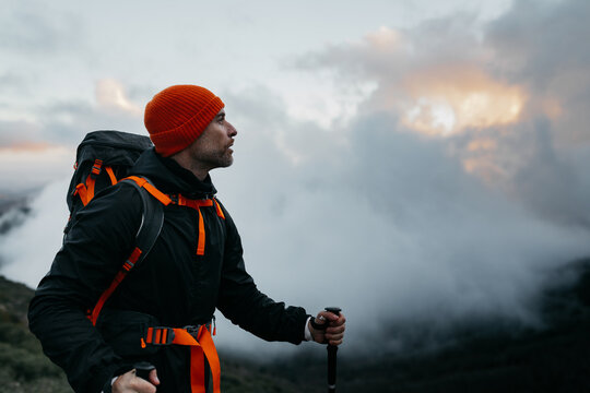 Hiker with backpack looking at mountain peak