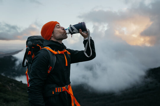 Hiker drinking from a bottle on a mountain trail