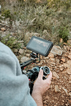 Person focusing camera using follow focus system and monitor outdoors