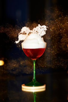Elegant cocktail with frothy topping in glass