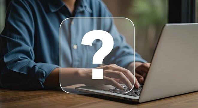 A person sitting at a desk with a laptop and a question mark overlay