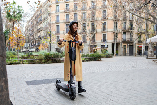 Woman enjoying urban e-scooter ride through city