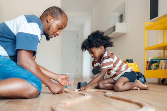 Father and daughter bonding over a toy train set