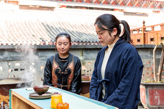 Women performing traditional tea ceremony outdoors