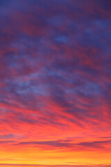Obraz premium Vertical red sunset sky with textured cloud formations.