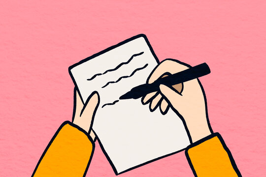 Writing on paper with a pen in hand