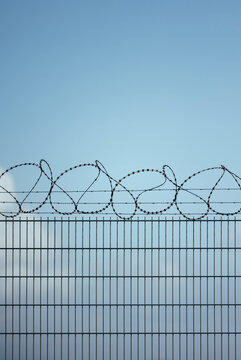 Barbed wire fence under clear blue sky